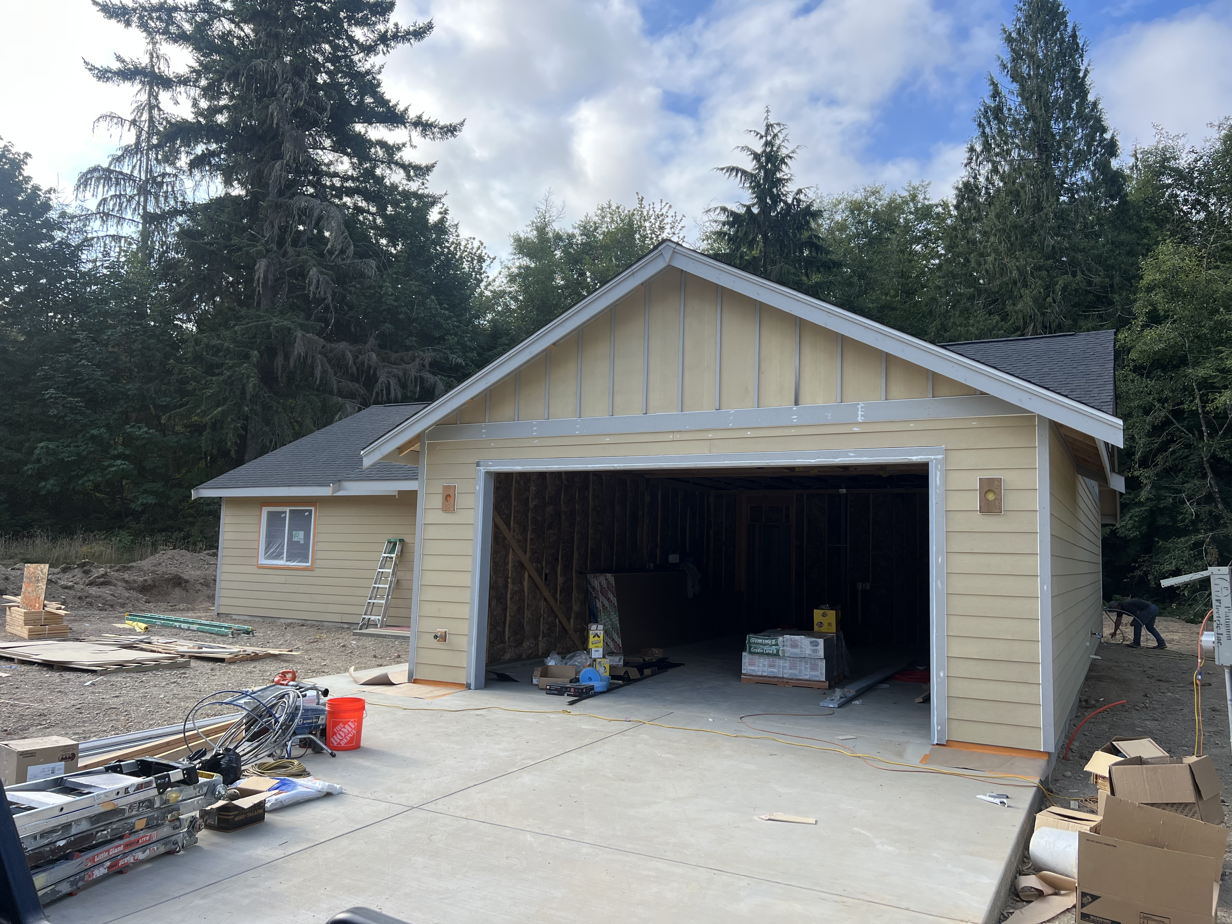 Cream-colored house and garage during exterior painting